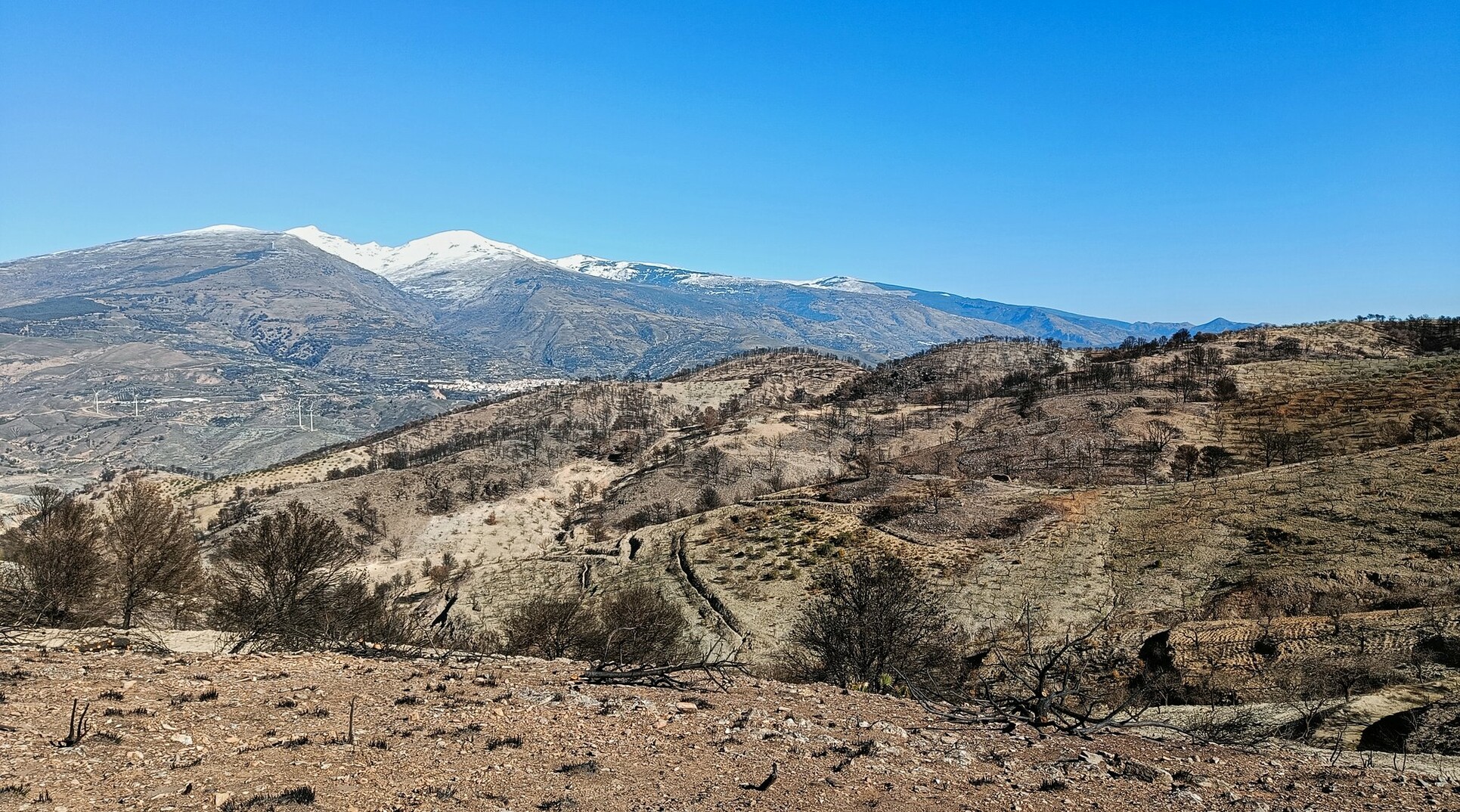 Lanjaron mid distance, behind the Sierra Nevada mountains and in front a devastated area from the wildfire in September